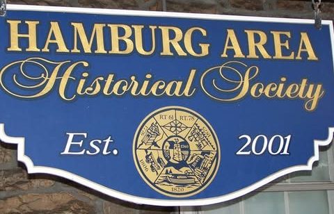 gold and blue sign hanging outside the hamburg area historical society office