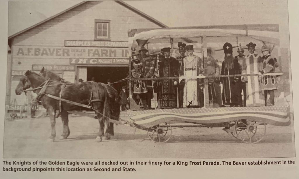 The Knights of the Golden Eagle dressed up and posing in their King Frost Parade float outside the Baver establishment modern day 2nd and State St