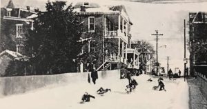 children sledding on island street