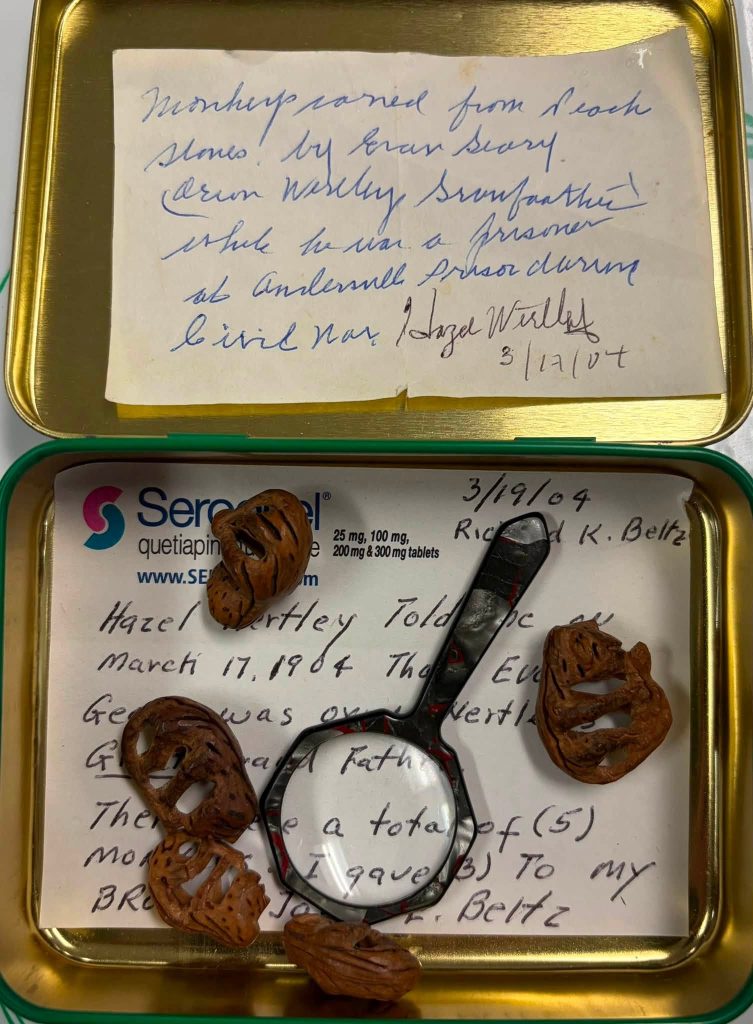 tin with a small magnifying glass to examine the tiny peach pit monkeys